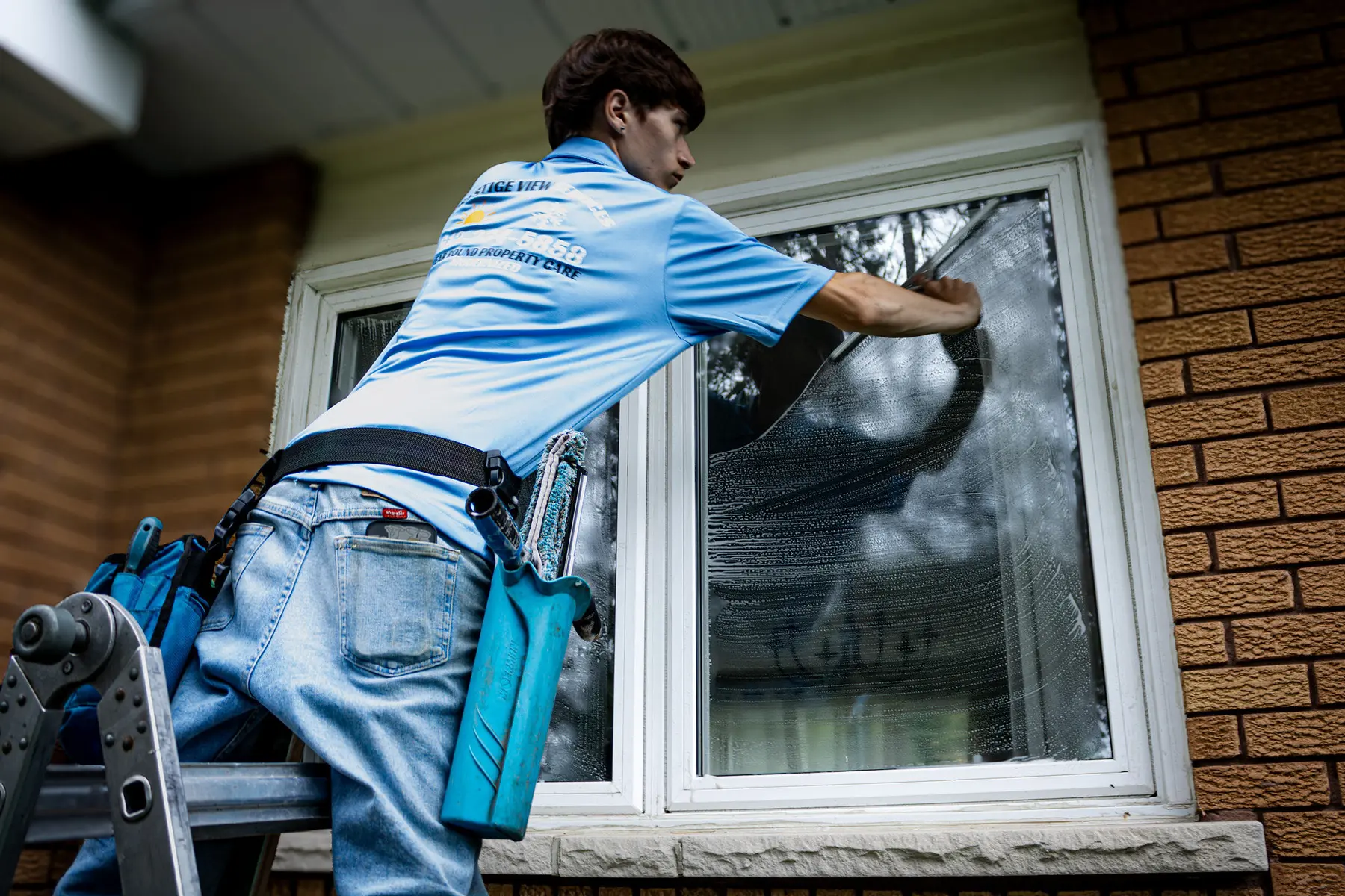 PVS crew member cleaning a window with a squeegee
