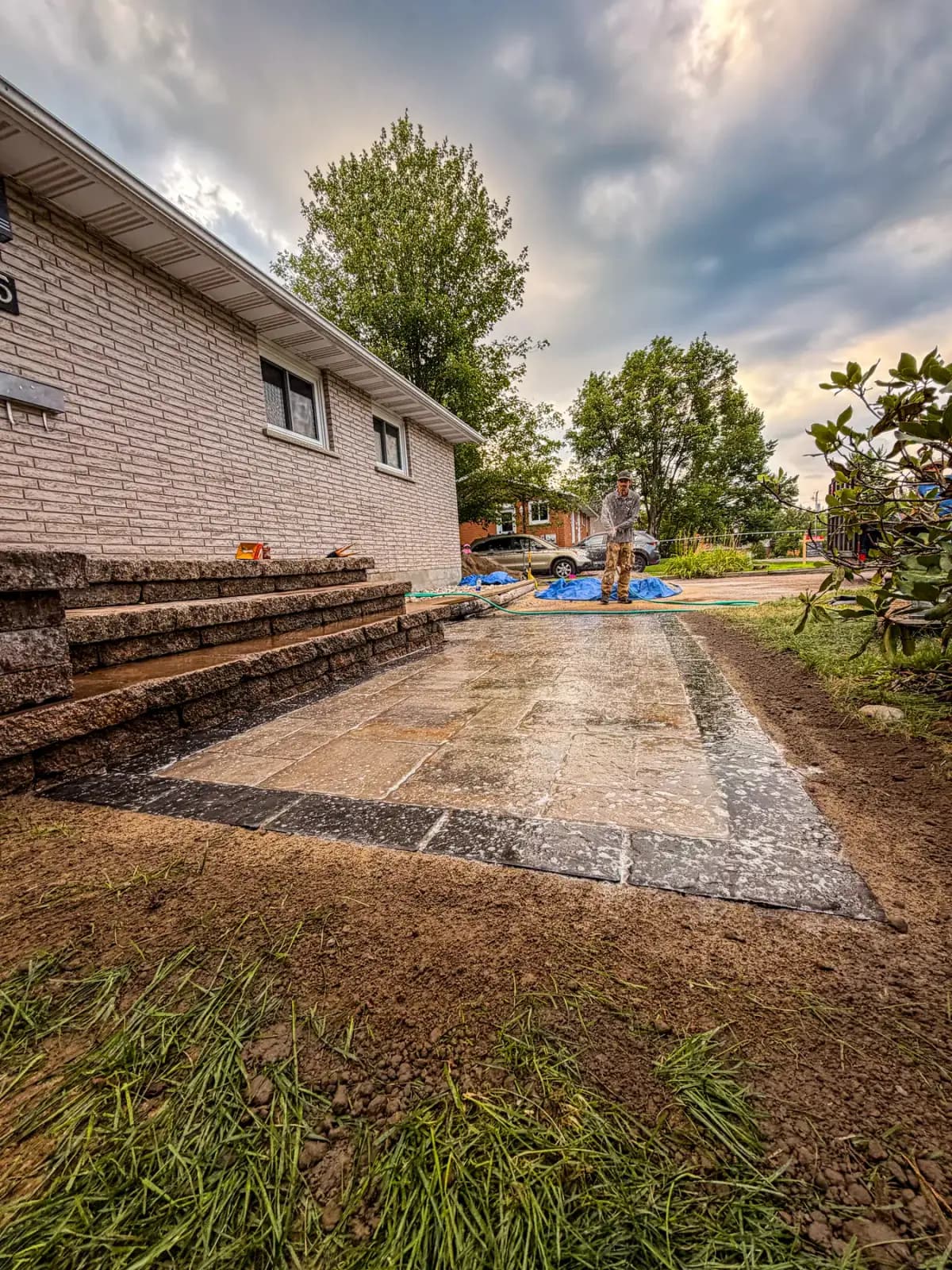 Finished interlock walkway being watered to set the polymeric sand joints