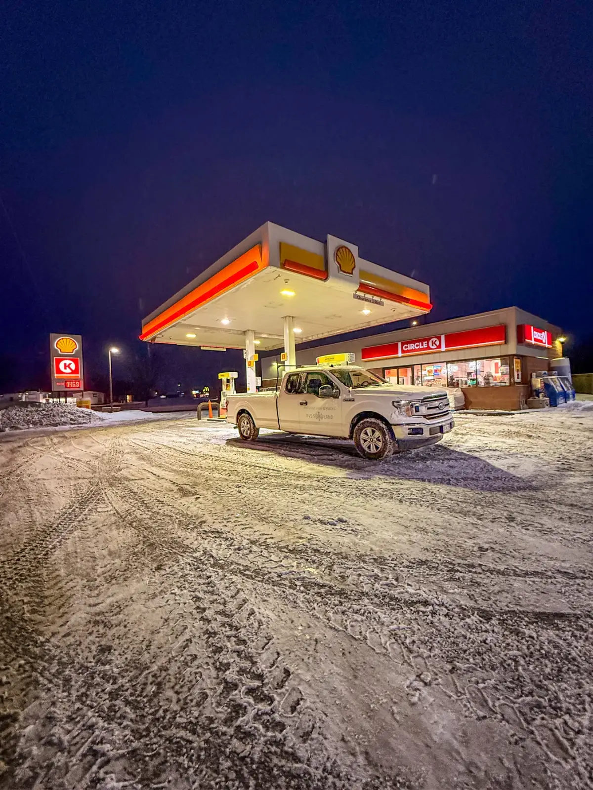 PVS truck clearing a commercial gas station lot during an overnight snowfall in Pembroke