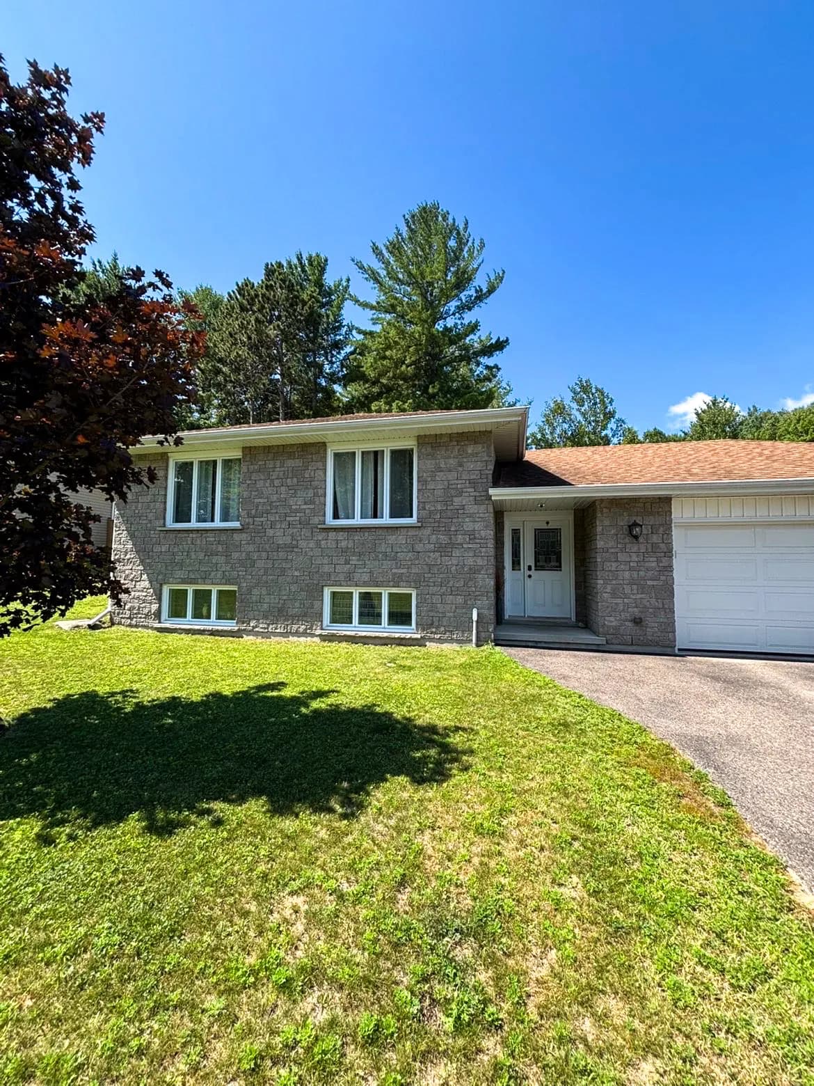 Stone bungalow with sparkling clean windows on a sunny day in Petawawa