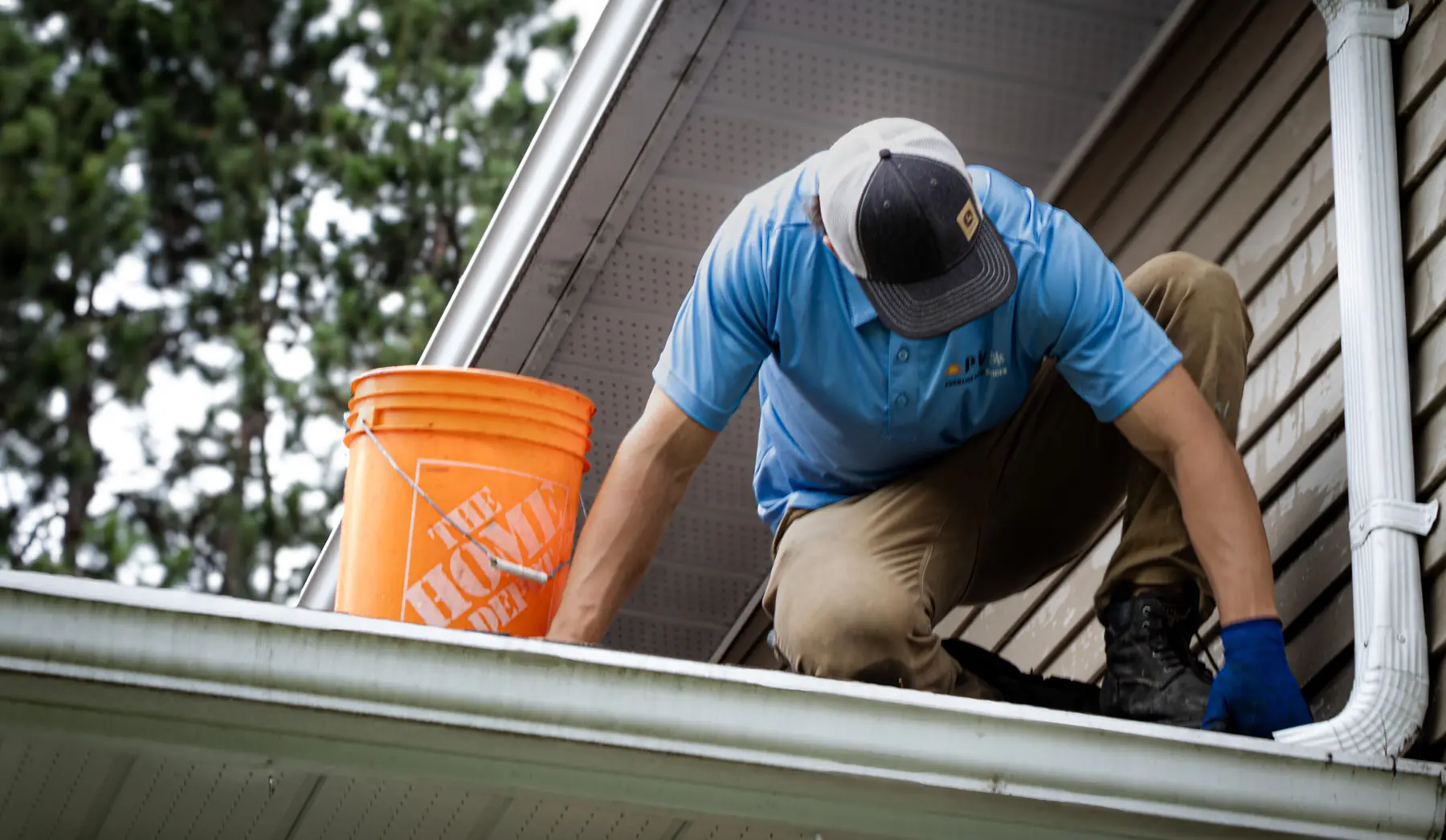 PVS crew member working along a roofline during a gutter cleaning