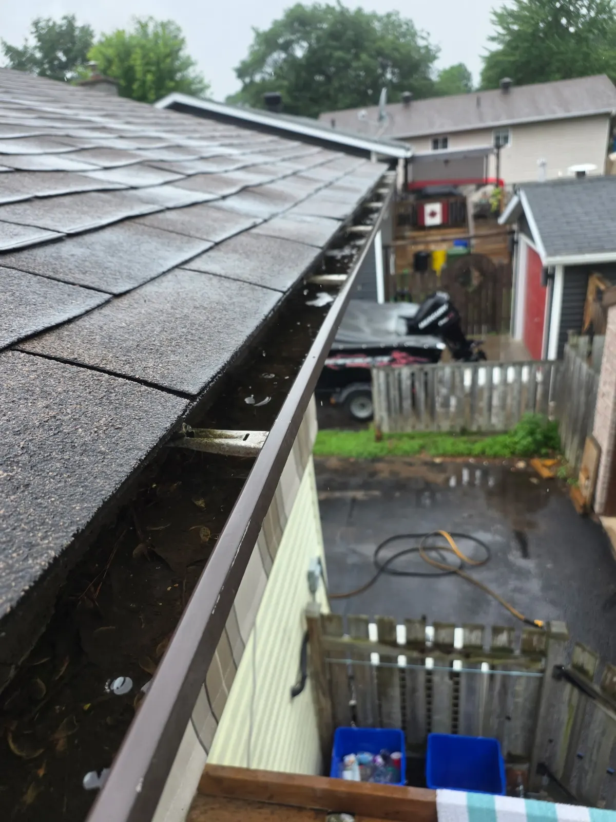 Gutter packed with compacted leaves and debris before cleaning