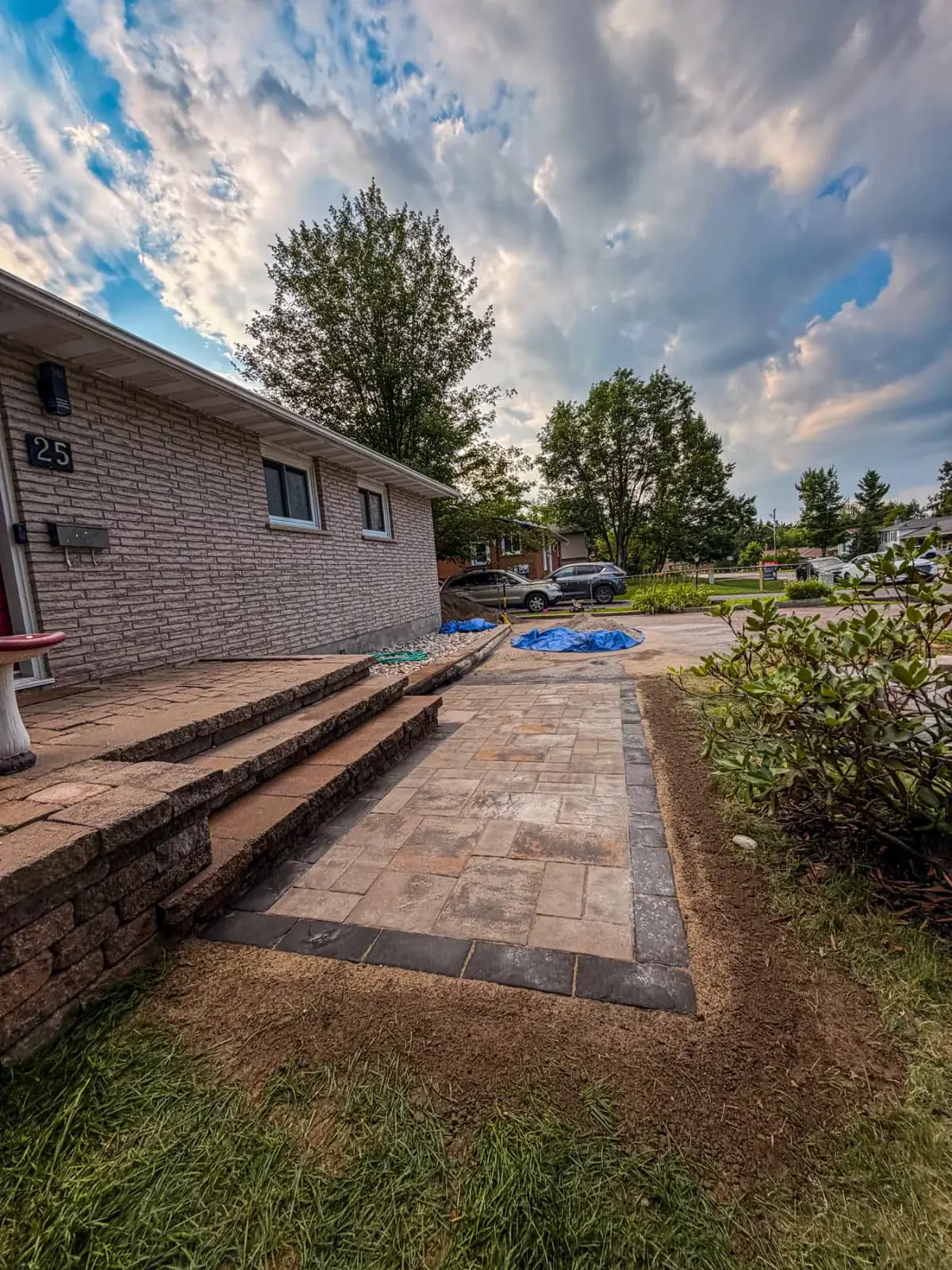 Finished interlock front walkway and stone steps at a Petawawa bungalow after a PVS rebuild.