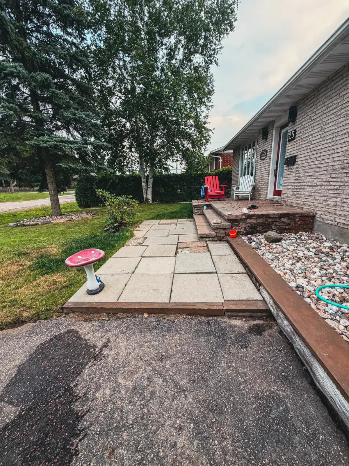 Aging patio-slab walkway with timber edging before the interlock rebuild.