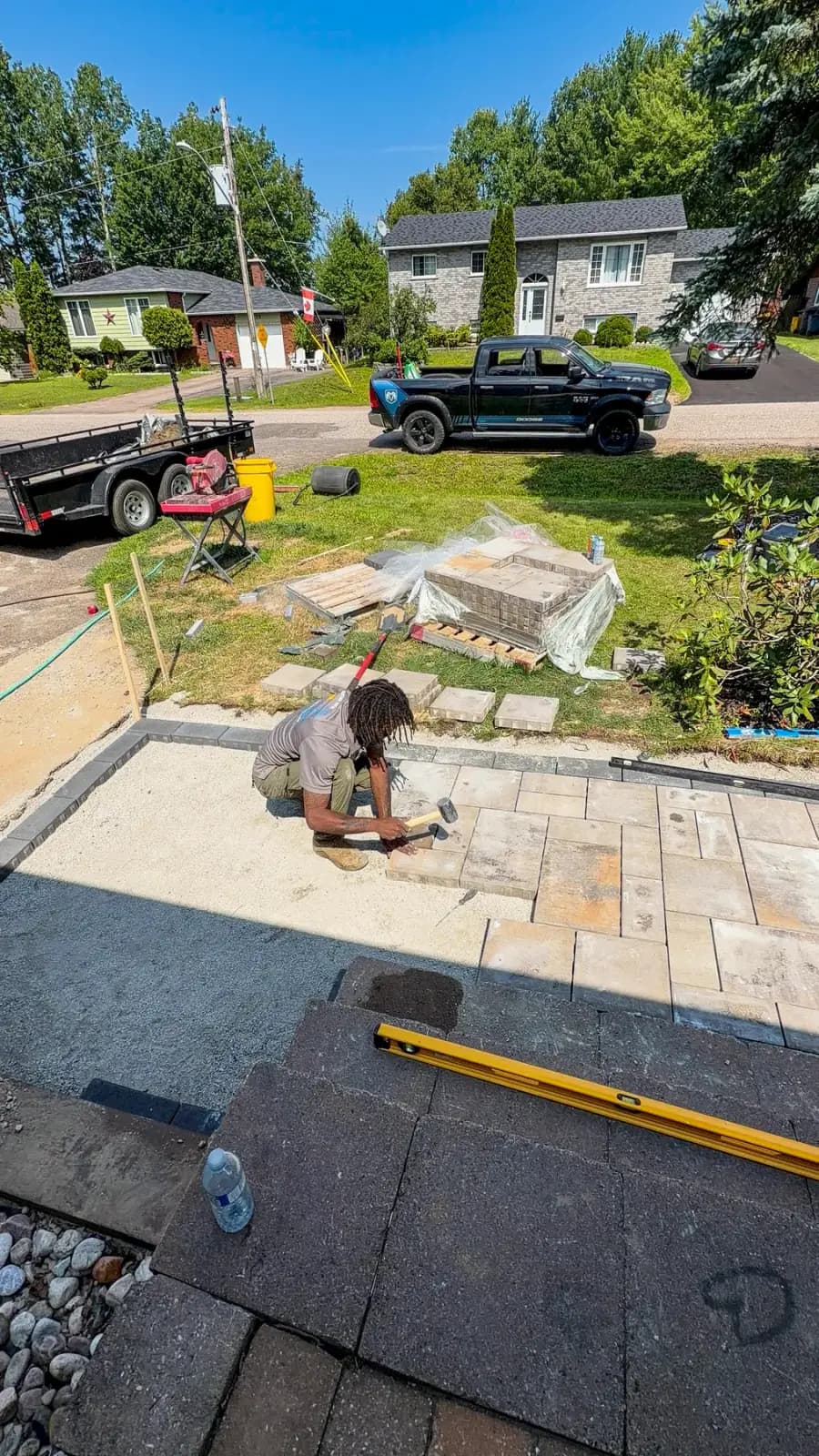 PVS crew member setting interlock pavers by hand with a rubber mallet