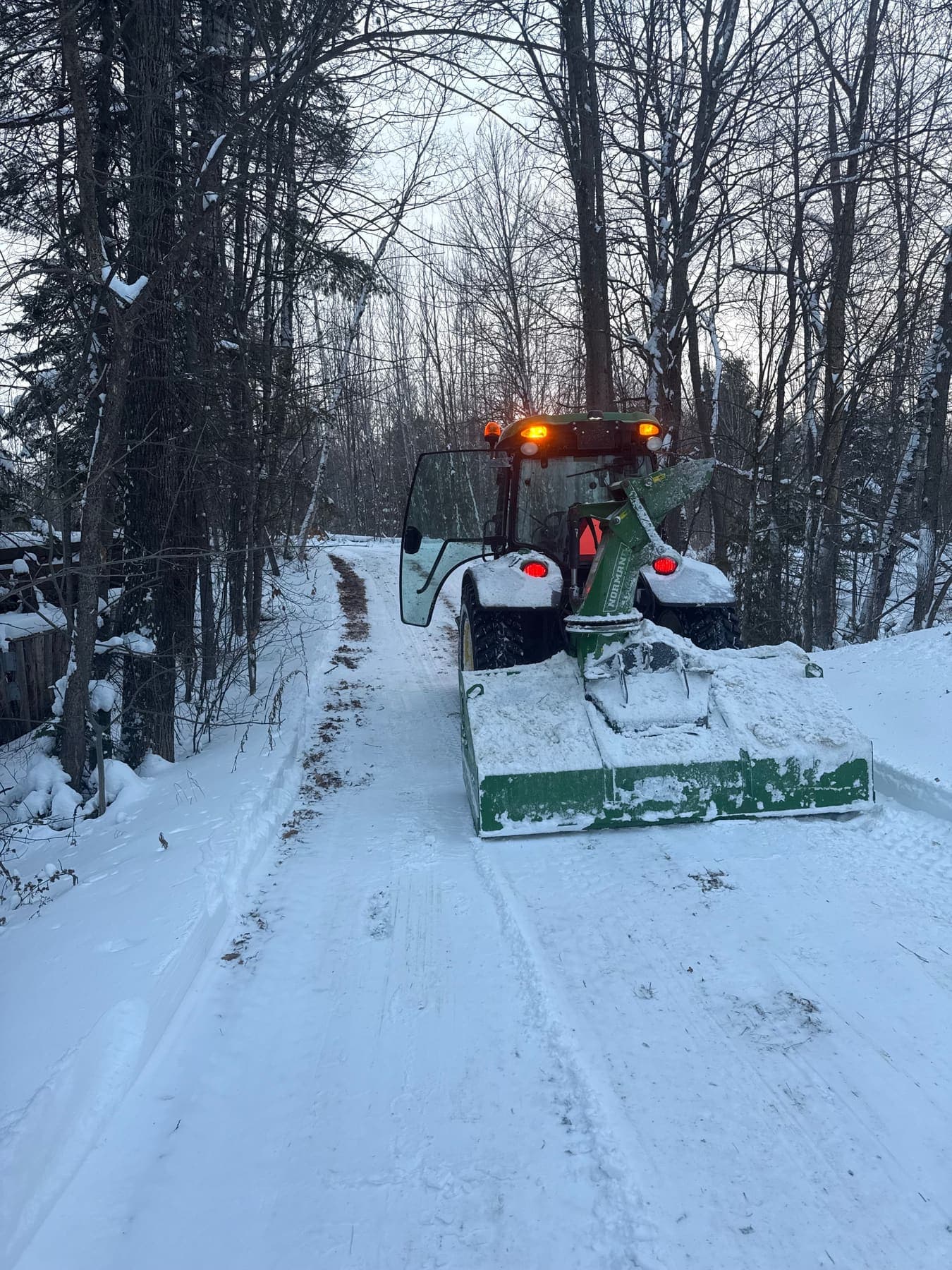 PVS SnowLand tractor with snowblower clearing a residential driveway