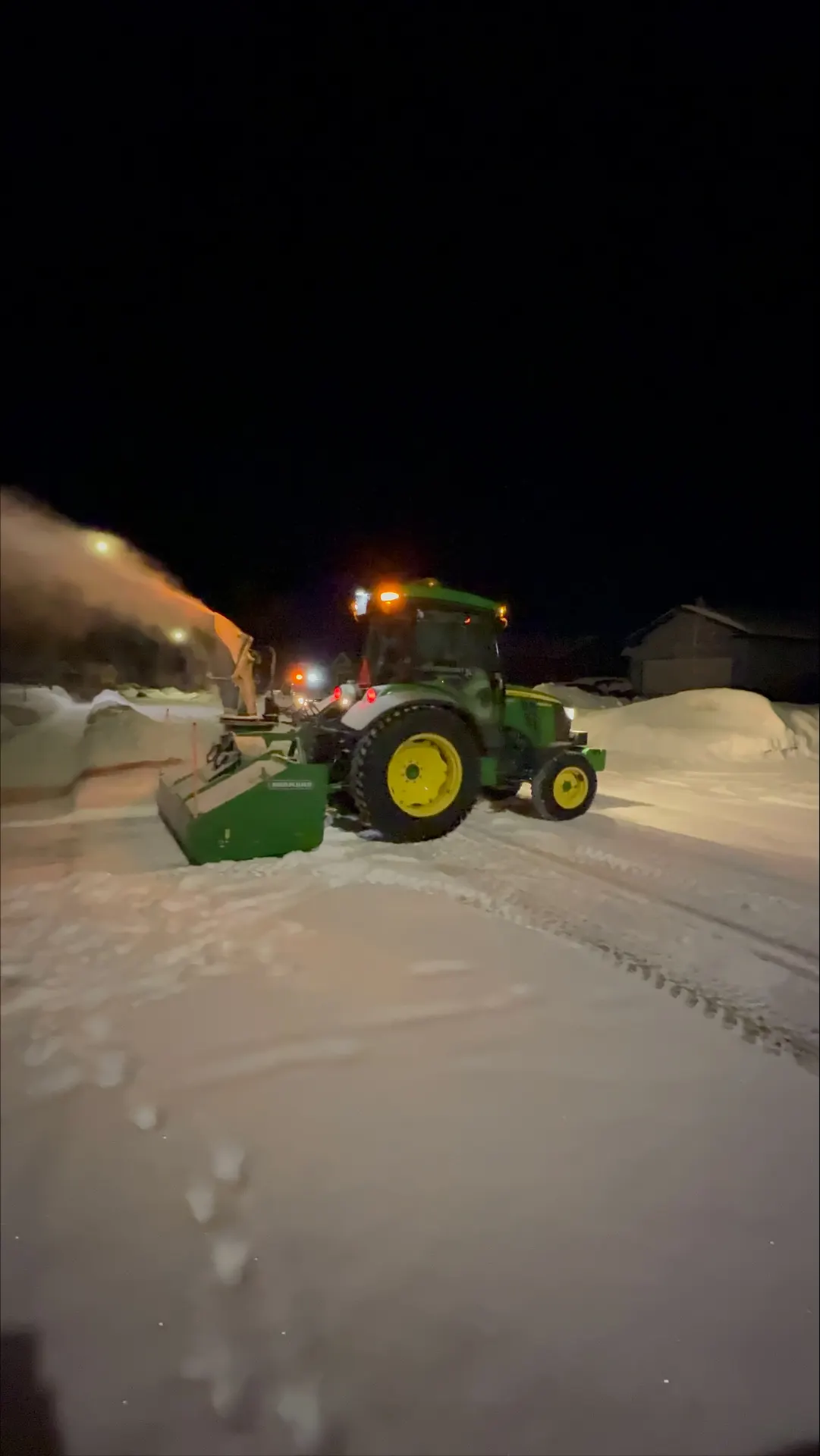 PVS tractor snowblowing a residential street after dark