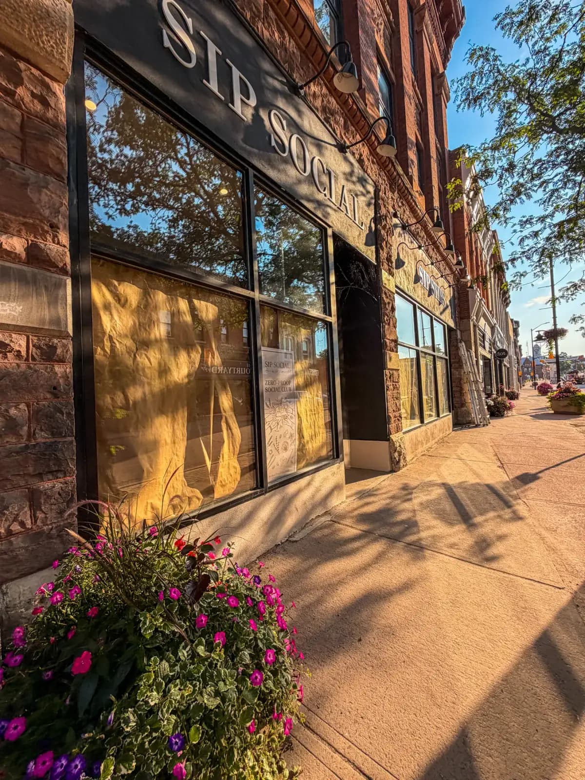 Downtown Pembroke storefront glass cleaned by PVS with ladders staged along the block