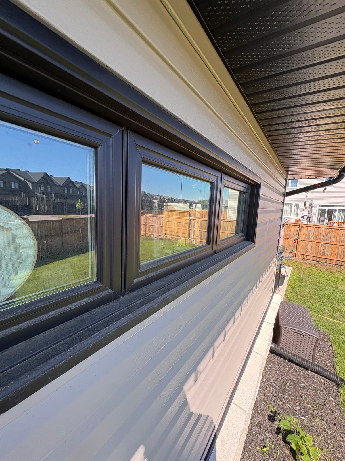 Modern home with dark-framed windows reflecting sky after PVS exterior cleaning