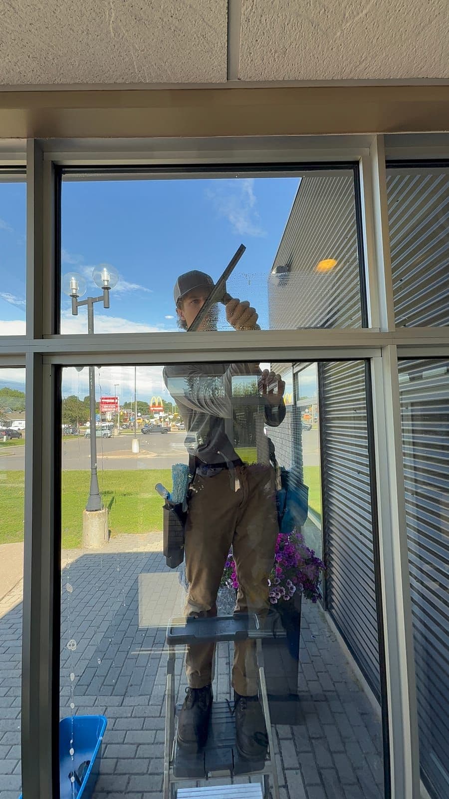 Prestige View Services technician squeegeeing a storefront window in Petawawa