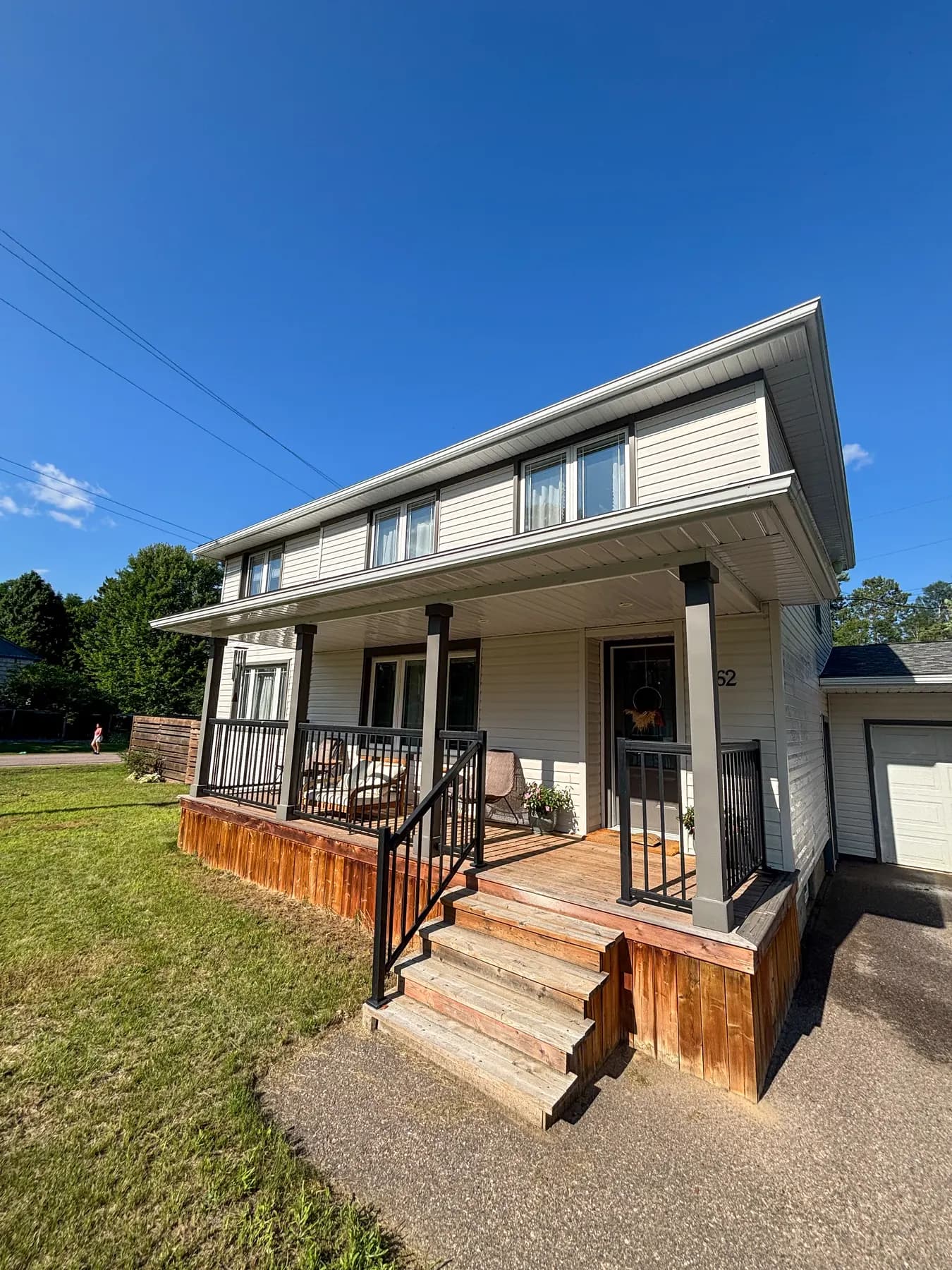Two-storey home with wraparound porch and streak-free windows after a PVS visit